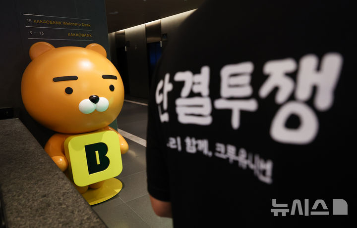 [성남=뉴시스] 김명년 기자 = 민주노총 화섬식품노조 카카오지회 조합원들이 21일 카카오뱅크가 입주한 경기 성남시 판교테크원에서 사측의 임금 인상률과 성과급 등 보상 체계를 규탄하는 피켓 시위를 하고 있다. 2026