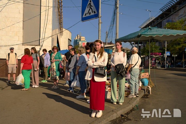 [키이우=AP/뉴시스] 27일(현지 시간) 우크라이나 키이우에서 시민들이 러시아와의 전쟁에서 전사한 군인들을 추모하며 매일 전국적으로 진행되는 1분간의 묵념을 하고 있다.2026.08.27.