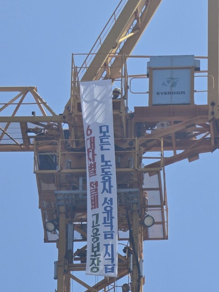 [거제=뉴시스] 신정철 기자= 강인석 전국금속노동조합 거제통영고성조선하청지회 지회장 등 조합원 6명은 30일 오후 12시 30분께 경남 거제시 한화오션 서문 인근 크레인과 공장 지붕 두 곳에서 "단체교섭 쟁취"를 내