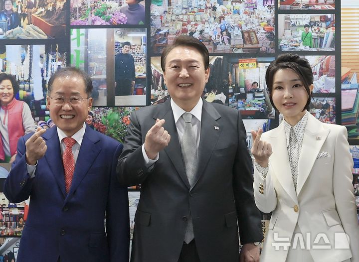 [대구=뉴시스] 윤석열 전 대통령과 부인 김건희 여사가 대구 서문시장 인근에서 열린 '서문시장 100주년 기념 특별사진전'을 찾아 당시 홍준표 대구시장과 기념촬영하고 있다. (사진=대통령실 제공) 2023.04.01