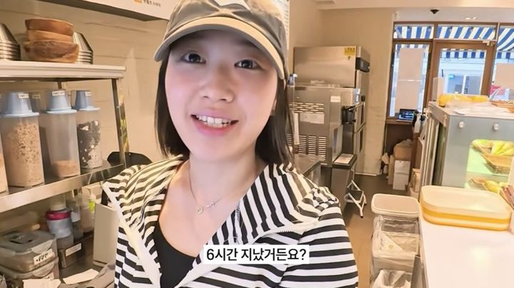 カフェの厨房で勤務中に自撮りするチェ・ユビン。画面には「6時間たったところ」と字幕が表示されている