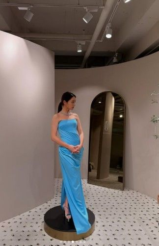 試着室で水色のロングドレスを着て立つイ・ミンジョン