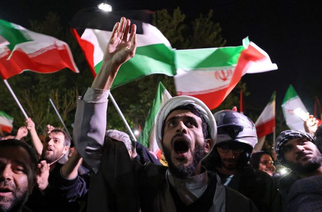 이스라엘에 대한 이란의 공격이 있은 14일(현지시간) 이란 테헤란 영국 대사관 앞에서 이란 시위대가 이란과 팔레스타인 국기를 들고 있다. AFP연합뉴스