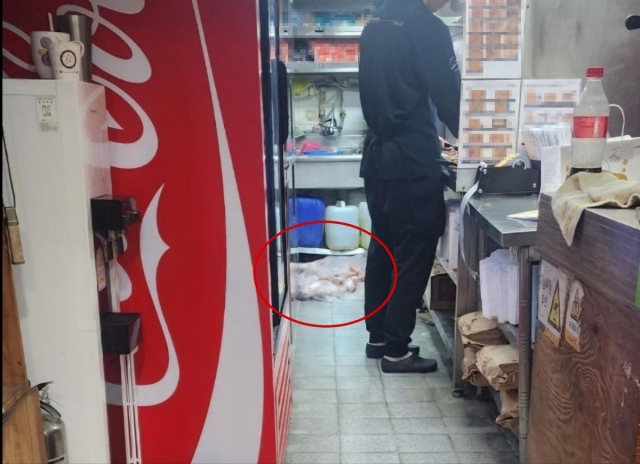 유명 치킨 프랜차이즈의 한 점포에서 생닭들을 더러운 바닥에 방치한 채 튀김 작업을 하는 모습이 소비자의 폭로로 드러났다. 온라인 커뮤니티 캡처, 연합뉴스