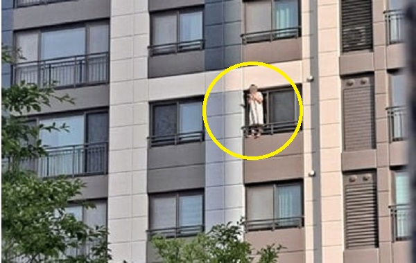 고층 아파트 창틀에 올라서서 담배를 피우는 남성. 온라인 커뮤니티 캡처