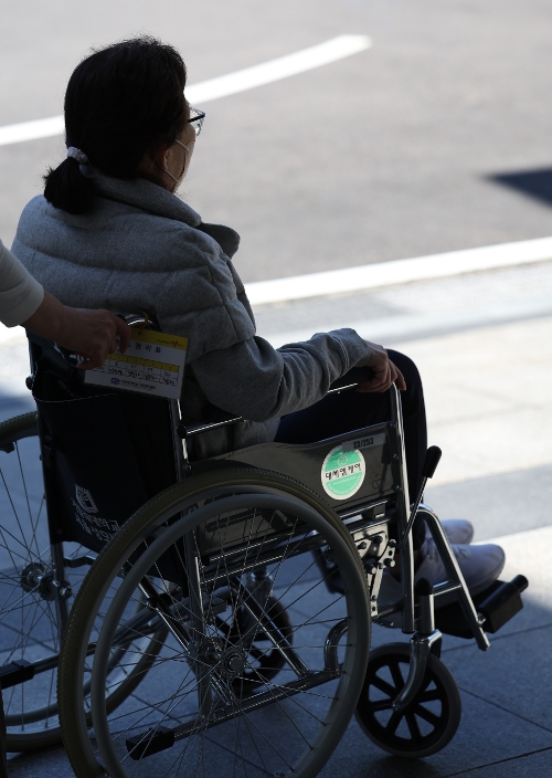 한 환자가 28일 서울 한 대학병원에서 휠체어를 탄 채 이동하고 있다. 이날은 지난 2월 19일 전공의들이 집단행동을 시작한 지 100일째 되는 날이다. 연합뉴스
