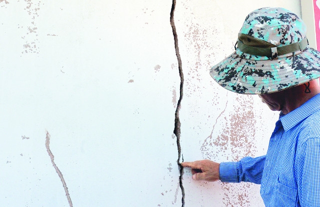 흥산마을회관 인근 주민이 지진으로 갈라진 벽을 살펴보고 있다. 뉴시스