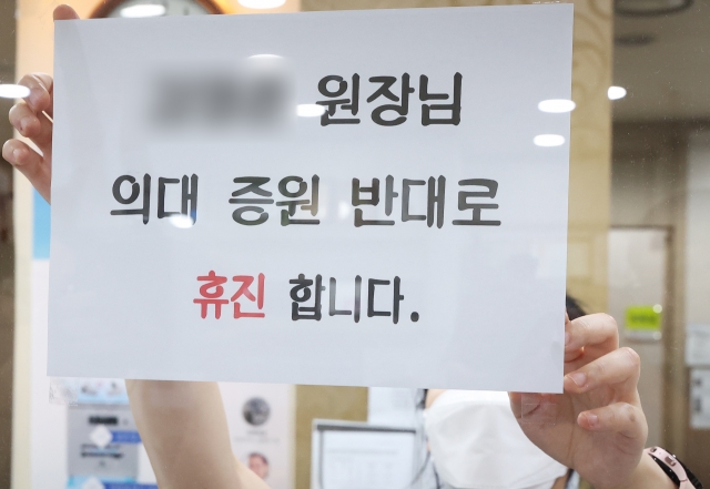 의료계 집단 휴진을 하루 앞둔 17일 오후 경기도 한 의원에서 관계자가 휴진 안내문을 붙이고 있다. 연합뉴스