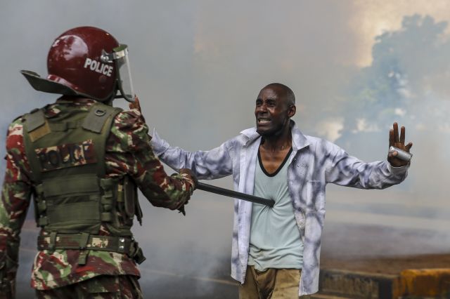 케냐 수도 나이로비의 중심업무지구에서 20일(현지시간) 한 증세 반대 시위 참가자가 경찰관에게 투항하고 있다. EPA연합뉴스