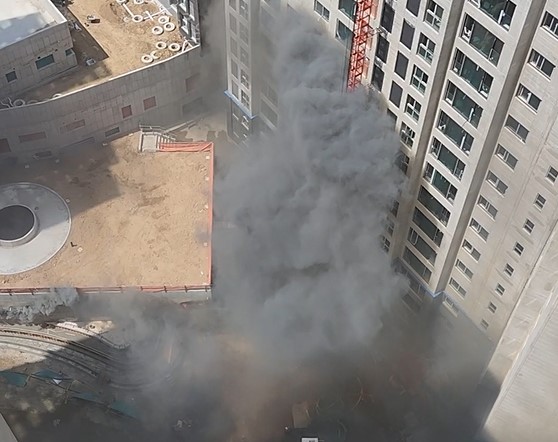25일 서울 동대문구 이문동 한 아파트 건축 현장에서 화재가 발생했다. 사진은 지하주차장에서부터 검은 연기가 솟아오르는 모습. 독자 제공 