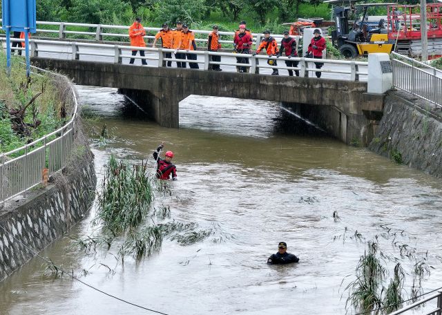 지난 9일 오후 경북 경산시 진량읍 평사리 소하천에서 소방 구조대가 폭우에 실종된 여성을 수색하고 있다. 연합뉴스