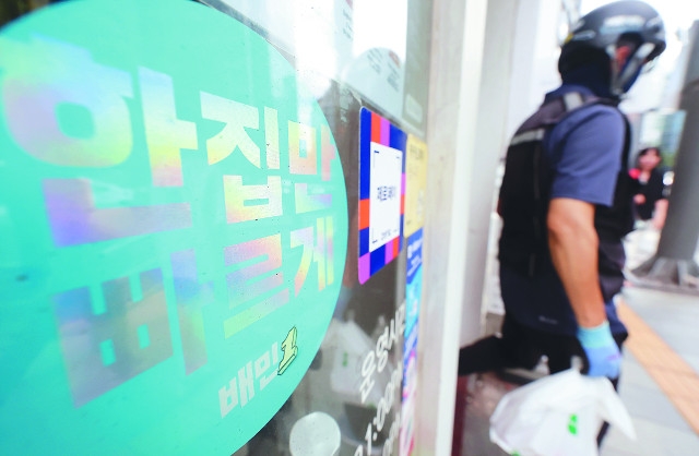배달기사가 10일 ‘배민1’ 스티커가 붙은 서울의 한 카페에서 배달음식을 들고 나서고 있다. 배달의민족은 다음 달부터 입점업체에 받는 중개수수료율을 현행 6.8%에서 9.8%로 인상하기로 했다. 뉴시스