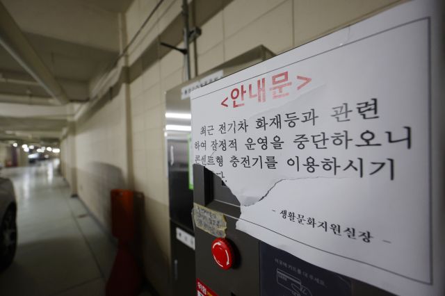 A notice of the suspension of operation is attached to a fixed electric vehicle charger installed in the underground parking lot of an apartment in downtown Seoul on the 12th. Yonhap News