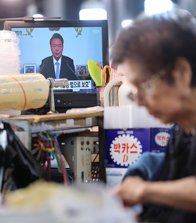On the morning of the 29th, the screen of a shop in a traditional market in Seoul shows a live broadcast of President Yoon Suk-yeol's national briefing and press conference. Yonhap News