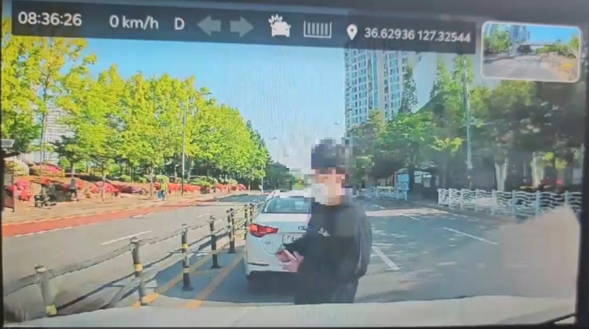 충북 청주의 한 고등학교에서 흉기 난동을 벌인 A군이 28일 도주 도중 B씨의 차량에 접근하는 모습이 담긴 블랙박스 화면. A군은 아이들이 탄 차량 뒷좌석 창문을 노크했다가 B씨가 운전석 문을 열자 커터칼로 B씨의