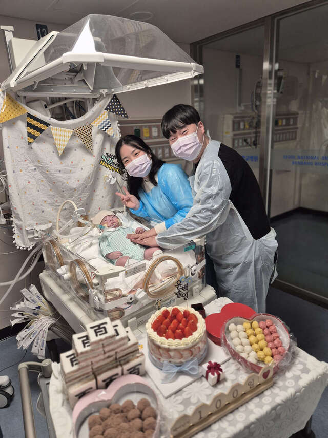 지난 2월 경기도 성남시 분당서울대병원 중환자실에서 백일을 맞은 솔이와 부모 안지은·윤석현씨가 환하게 웃으며 기념 촬영을 하고 있다.아래 사진은 백일반지를 낀 솔이의 작은 손이 엄마 아빠 손 위에 포개진 모습.안