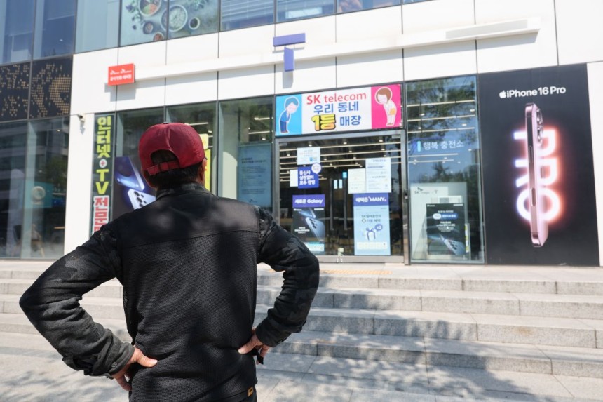 지난 2일 서울 시내의 한 SK텔레콤 대리점 앞에서 한 소비자가 유심 재고 소진 안내문을 한참 바라보고 있다. 연합뉴스