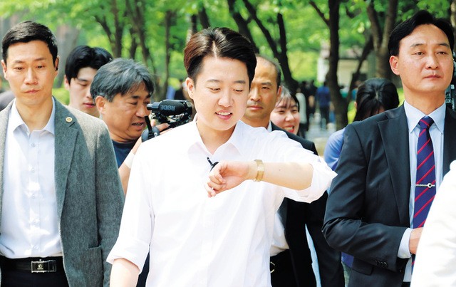 이준석 개혁신당 대선 후보가 28일 서울 여의도공원 유세에서 직장인들에게 인사하던 중 손목시계를 바라보고 있다. 이 후보는 전날 TV토론에서 여성 신체를 지칭한 원색적 발언에 대해 사과했다. 연합뉴스