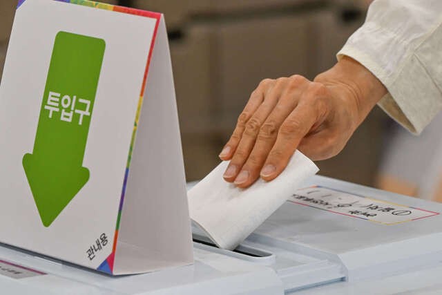 제21대 대통령선거 사전투표일인 29일 서울 종로구 혜화동 사전투표소에서 한 유권자가 지지 후보를 기입한 투표용지를 투표함에 넣고 있다. 윤웅 기자
