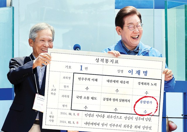 이재명 더불어민주당 대선 후보가 1일 경북 안동 웅부공원 유세 도중 자신의 초등학교 은사인 박병기 교사로부터 정치 활동을 잘했다는 가상 성적통지표를 받고 환하게 웃고 있다. 안동=이병주 기자