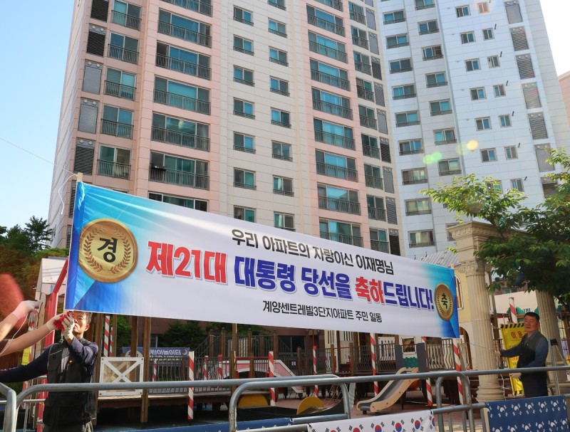 “우리 아파트 자랑” <b>현수막</b> 붙은 사저… 환호 속 첫 출근