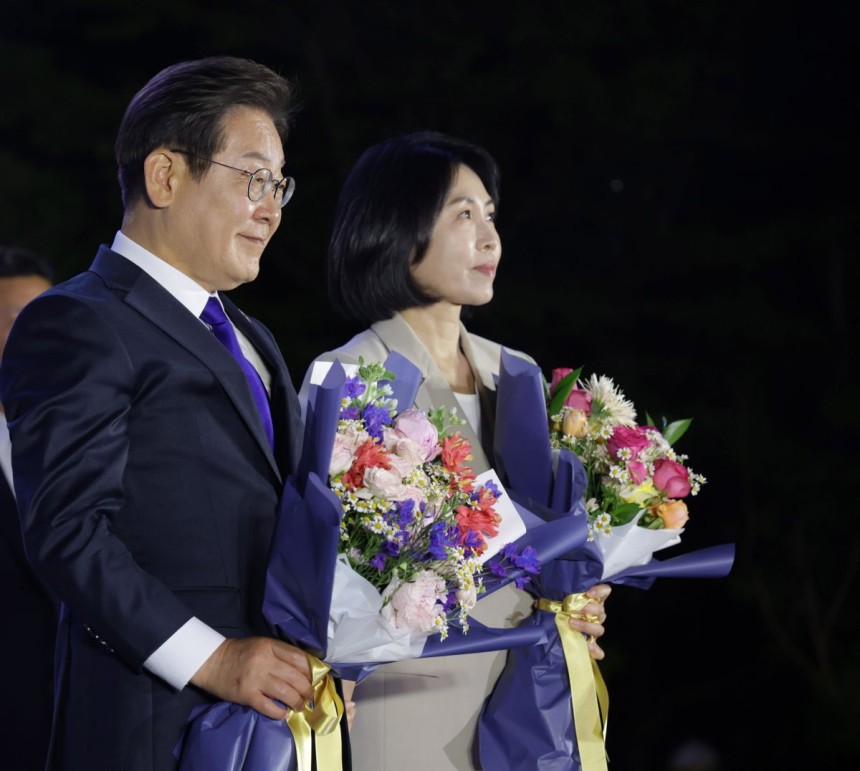 제21대 대통령 당선이 확실시되는 이재명 더불어민주당 대선 후보와 부인 김혜경 여사가 4일 서울 여의도 국회 인근에서 당 주최로 열린 국민개표방송 행사에 참석해 축하 꽃다발을 받고 있다. 공동취재, 연합뉴스