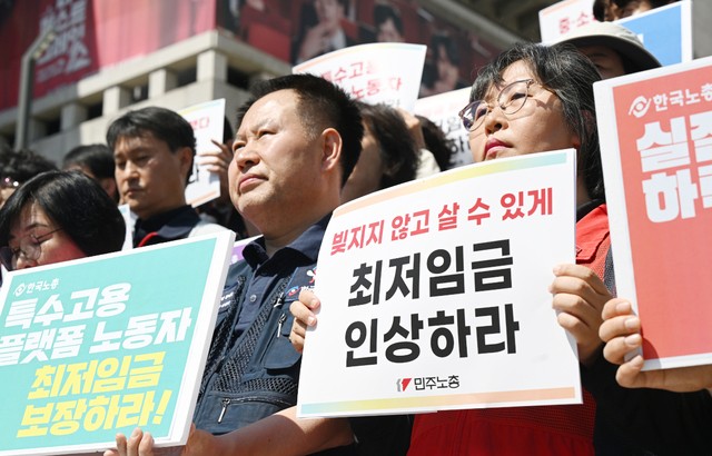한국노동조합총연맹과 전국민주노동조합총연맹 소속 조합원 등이 11일 서울 종로구 세종문화회관 앞에서 최저임금 인상을 촉구하는 손팻말을 들고 있다. 이들은 내년 최저임금으로 올해보다 14.7% 오른 시급 1만1500원을