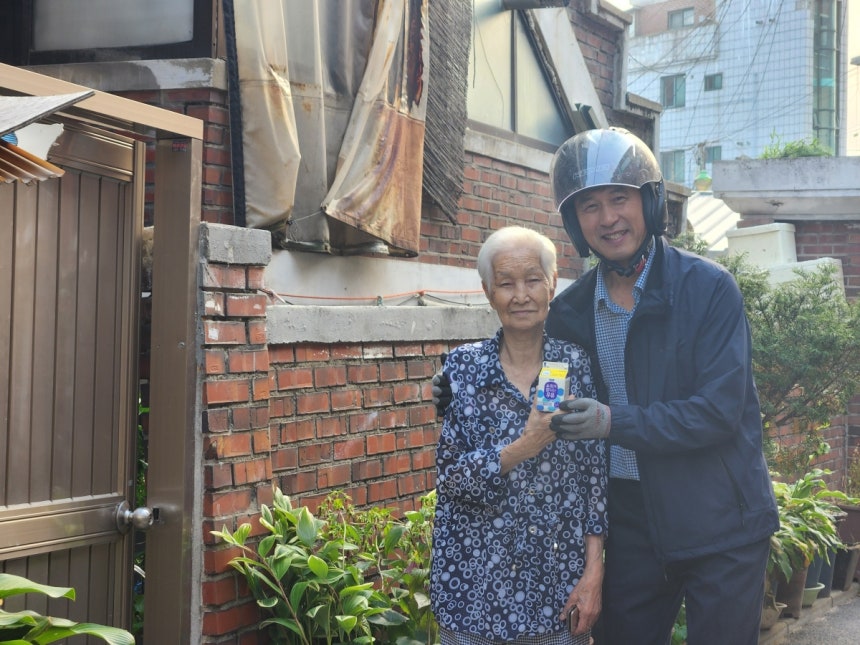 구지영 매일유업 성동·광진 대리점장이 18일 서울 성동구의 김용남 할머니 댁 앞에서 김 할머니와 우유를 들고 있다.  