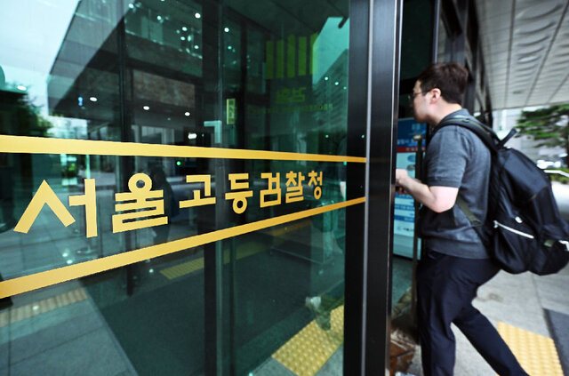 한 관계자가 26일 내란 특검 사무실이 마련된 서울 서초구 서울고등검찰청으로 들어가고 있다. 12·3 비상계엄 사태를 수사한 경찰청 국가수사본부 비상계엄 특별수사단은 이날 수사 기록과 증거물을 특검에 넘기고 해산했다