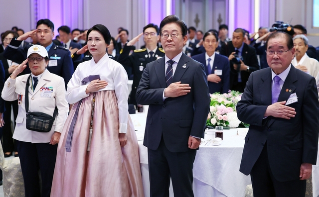 이재명 대통령과 김혜경 여사가 27일 청와대 영빈관에서 열린 ‘호국보훈의 달, 대통령의 초대’ 오찬 행사에서 국민의례를 하고 있다. 이종찬(오른쪽) 광복회장을 비롯해 국가유공자 및 보훈가족 등 160여 명이 참석했다