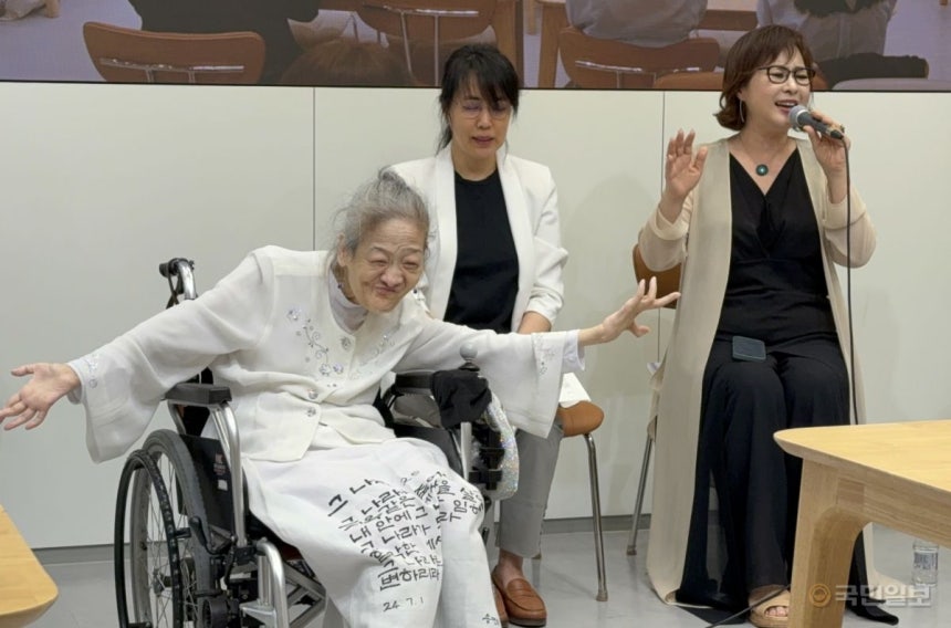 송명희 시인(왼쪽 첫 번째)이 21일 성남 만나교회에서 열린 ‘40주년 기념 시집 발표회’에서 찬양사역자 송정미(오른쪽 첫 번째)의 찬양에 맞춰 휠체어에 앉은 채 춤을 추고 있다.