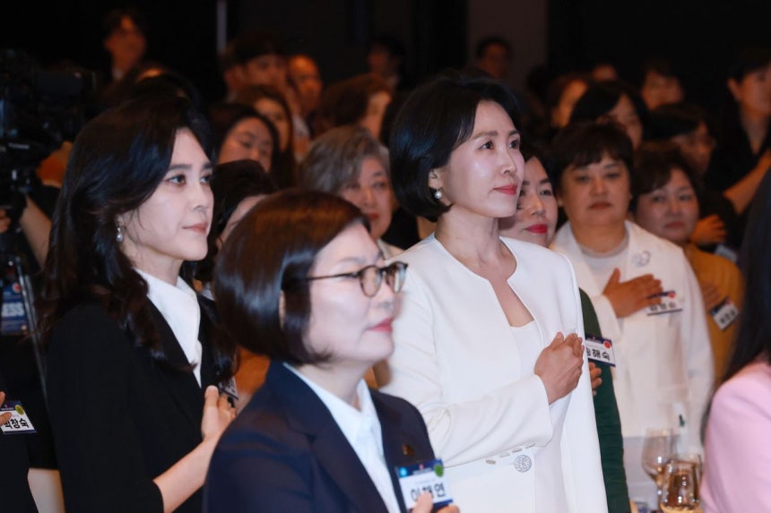 이재명 대통령의 배우자 김혜경 여사가 1일 서울 중구 신라호텔 다이너스티홀에서 열린 제4회 여성기업주간 개막식에 참석해 국기에 경례하고 있다. 왼쪽은 이부진 호텔신라 사장. 연합뉴스