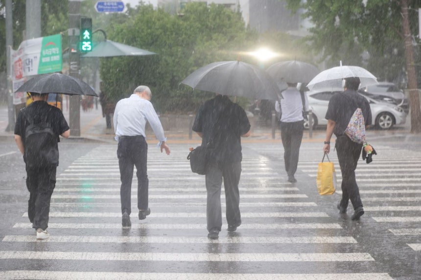 서울 서남권에 호우주의보가 발효된 8일 서울 영등포구 여의도 국회 인근에서 시민들이 우산을 쓰고 이동하고 있다. 연합뉴스