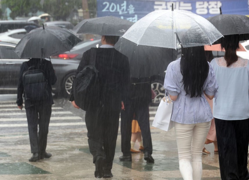 서울 서남권에 호우주의보가 발효된 8일 서울 영등포구 여의도 국회 인근에서 시민들이 우산을 쓰고 이동하고 있다. 연합뉴스
