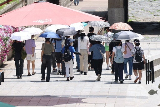 서울지역에 이틀째 폭염주의보가 지속중인 1일 서울 중구 청계천 인근에서 시민들이 양산을 쓰고 이동하고 있다. 뉴시스