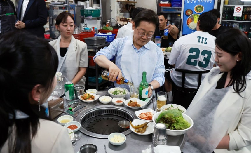  이재명 대통령이 11일 저녁 서울 광화문 인근 한식당에서 시민들과 식사 중 술을 따르고 있다. 연합뉴스