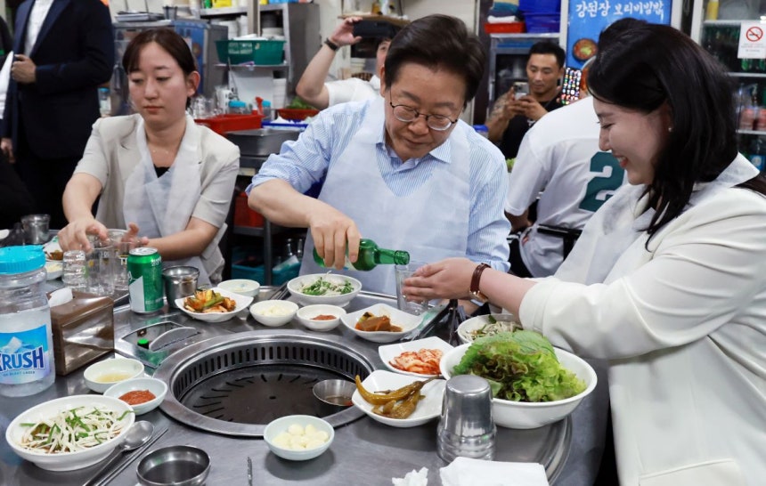  이재명 대통령이 11일 저녁 서울 광화문 인근 한식당에서 시민들과 식사 중 술을 따르고 있다. 연합뉴스