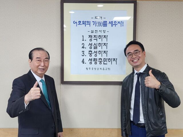 김상용 원로목사와 안호성 위임목사가 지난 14일 충북 청주시 서원구 청주중앙순복음교회 당회장실에서 교회 표어가 담긴 액자를 배경으로 엄지를 들어 보이며 밝게 웃고 있다. 교회는 다