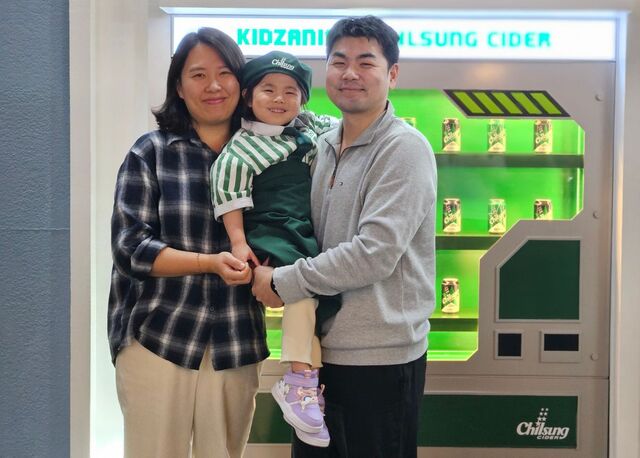 듀센근이영양증을 진단받은 전사랑(가운데)양이 지난 21일 서울 송파구 키자니아에서 직업 체험을 하던 중 부모님 품에 안겨 웃고 있다.