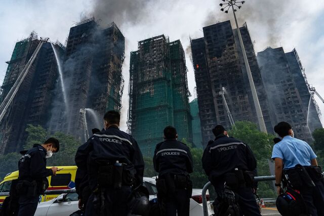 27일 홍콩 북부 타이포 구역의 고층 아파트 단지 ‘웡 푹 코트’에서 화재 진화 작업이 진행되는 가운데 경찰이 주변을 통제하고 있다. 전날 낮부터 발생한 화재로 7개 동이 불에 탔고 막대한 인명 피해가 발생했다. A