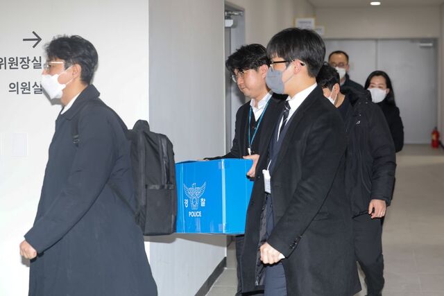 경찰 관계자들이 19일 서울 동작구의회에서 더불어민주당을 탈당한 김병기 무소속 의원의‘부인 법인카드 유용 의혹’과 관련해 의회 사무국 등을 압수수색한 뒤 압수품을 옮기고 있다.연합뉴스