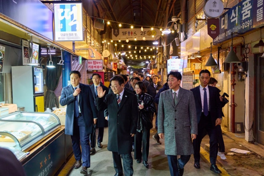 이재명 대통령이 9일 저녁 식사를 위해 방문한 서울 종로구 통인시장에서 상인들에게 인사하고 있다. 청와대 제공