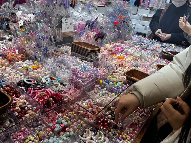 방문객이 다양한 볼펜 장식 액세서리 중 마음에 드는 것을 고르는 모습.