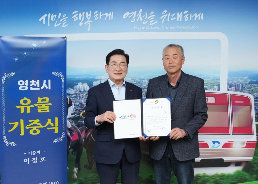 기증자 이정호(오른쪽) 씨가 최기문 영천시장과 기념 촬영하고 있다.          영천시 제공