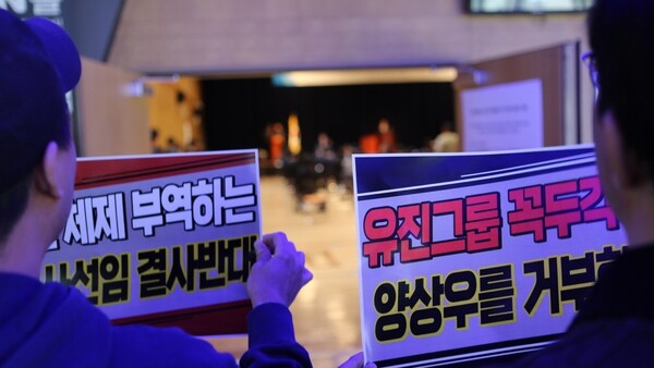 ▲27일 YTN 주주총회가 열린 서울 상암동 YTN 1층 주총 현장에서 언론노조 YTN지부 조합원들이 피켓을 들고 있는 모습.사진=언론노조 YTN지부 