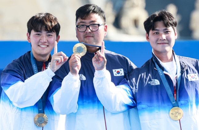 대한민국 양궁대표팀 김우진, 김제덕, 이우석이 30일(한국시간) 프랑스 파리 앵발리드에서 열린 2024 파리올림픽 양궁 남자 단체전 결승 시상식에서 메달과 손가락을 이용해 대한민국의 101번째 금메달을 표현하고 있다