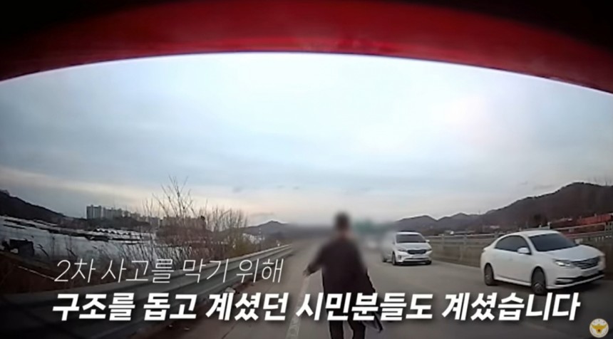 협심증을 앓는 남성이 운전 중 도로 한복판에 쓰러지자 시민들이 2차 사고를 막기 위해 구조를 돕고 있다./사진=경찰청 유튜브 갈무리 