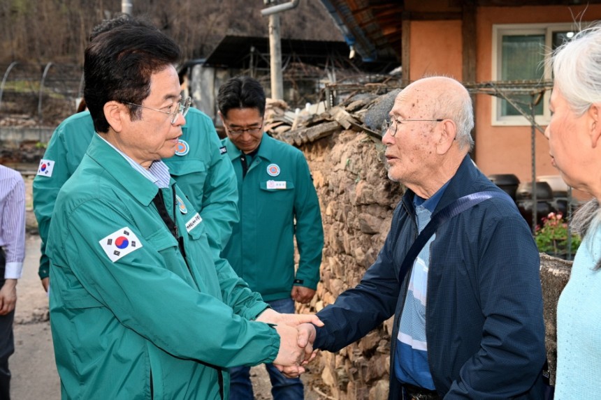 이철우 경북도지사(왼쪽)가 산불피해 지역 주민의 손을 잡고 위로하고 있다./사진제공=경북도