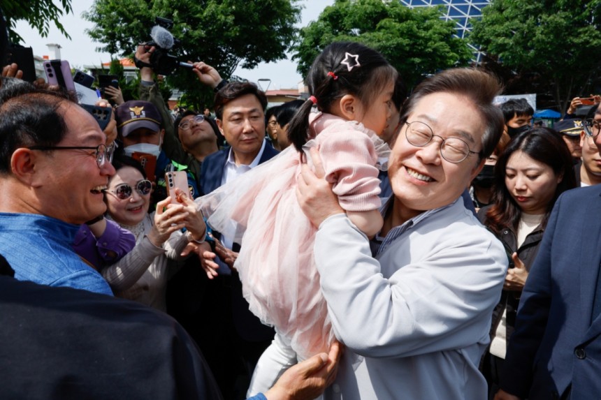 (전주=뉴스1) 안은나 기자 = 이재명 더불어민주당 대통령 후보가 2차 골목골목 경청투어 마지막 날인 7일 오후 전북 전주시 풍남문 앞에서 한 어린이를 안아들고 있다.2025.5.7/뉴스1 Copyright (C