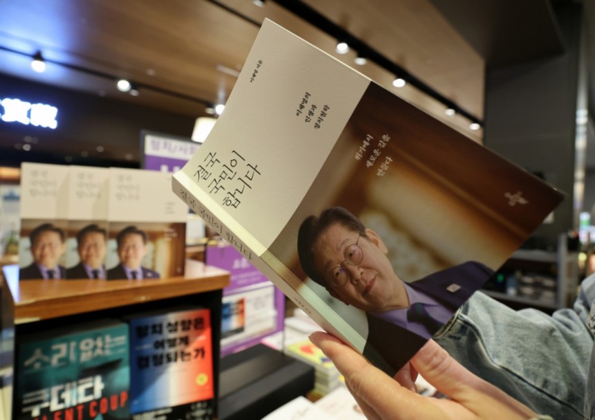 지난달 15일 서울 종로구 교보문고를 찾은 시민이 이재명 더불어민주당 대선후보가 쓴 책 '결국 국민이 합니다'를 살펴보는 모습./사진=뉴시스 
